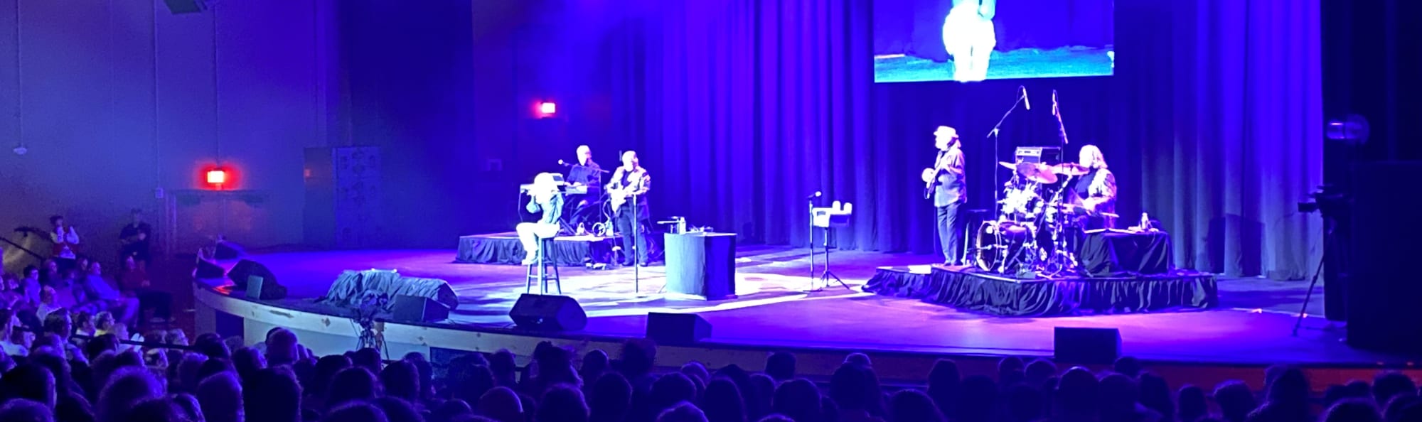 signer on stage in chair washed out by the lights Anchorage